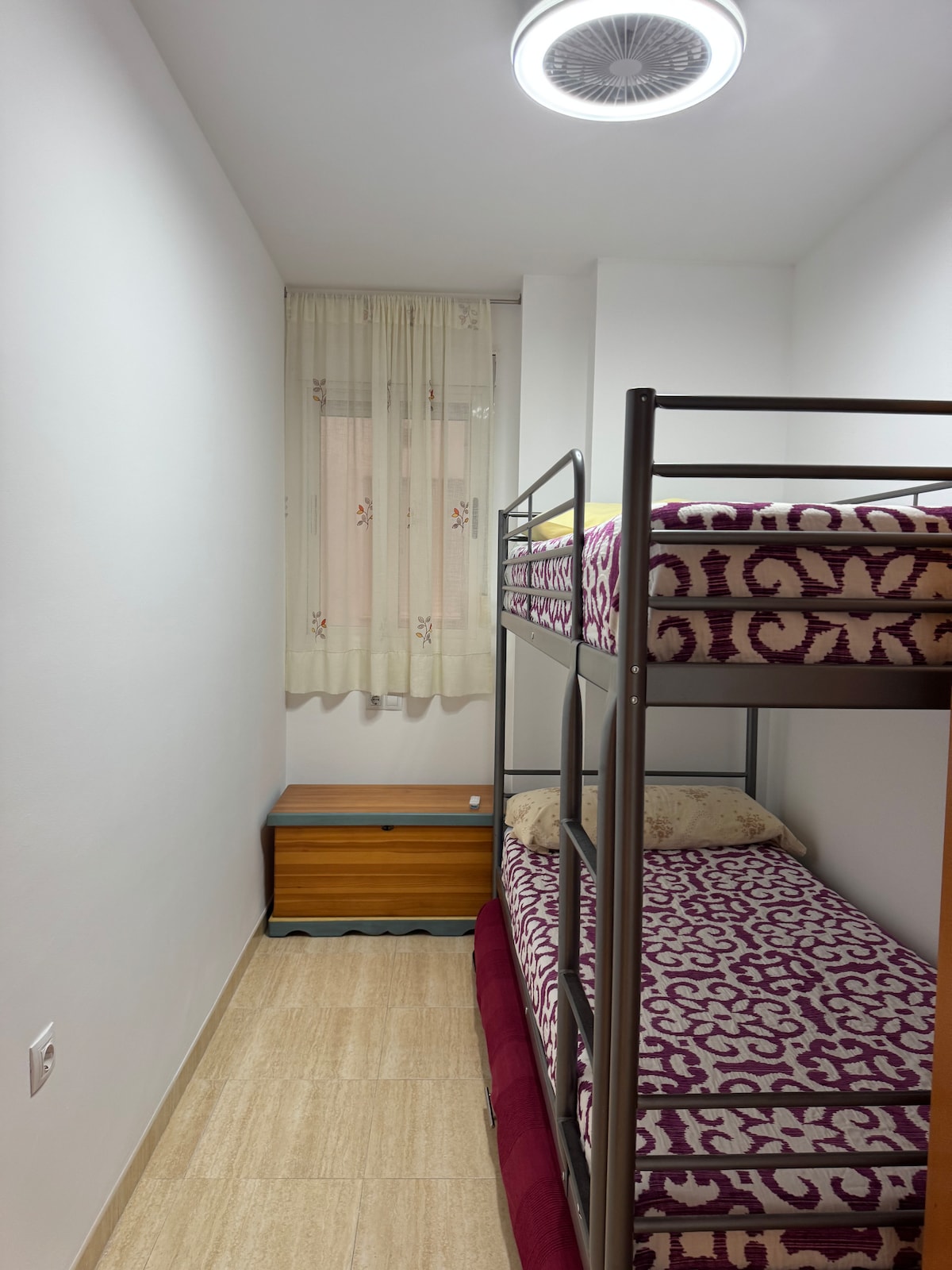 غرفة نوم ثالثة مع سرير بطابقين متين للغاية وسرير إضافي مع قاعدة زنبركية بعجلات في الطابق السفلي. مروحة مع مصباح LED مدمج في السقف 