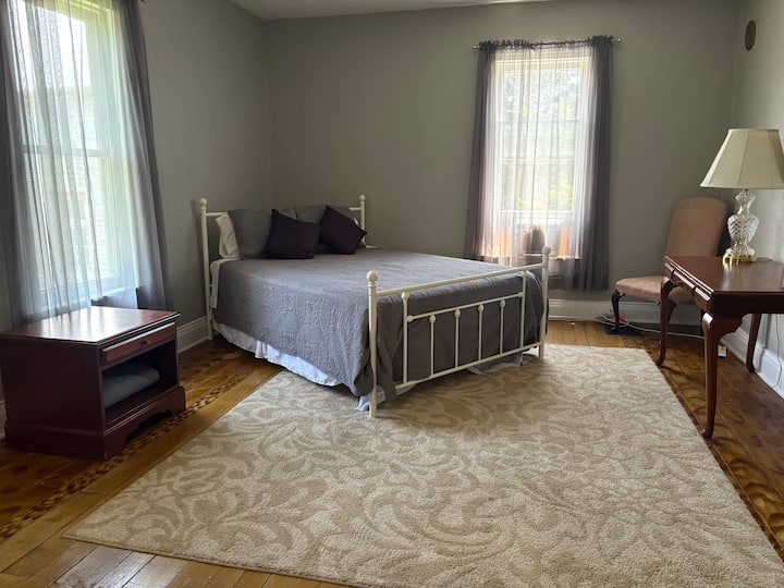 Bedroom #1: Large room with queen-size bed, desk, night stand and luggage rack.