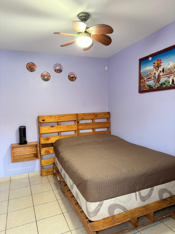 Ideal para quienes buscan fácil acceso y comodidad sin escaleras.
Equipada con cama matrimonial.
Tiene su propio baño completo privado.
Diseño funcional con un tocador, organizador tipo clóset y un buró rústico.
Dispone de un ventilador.