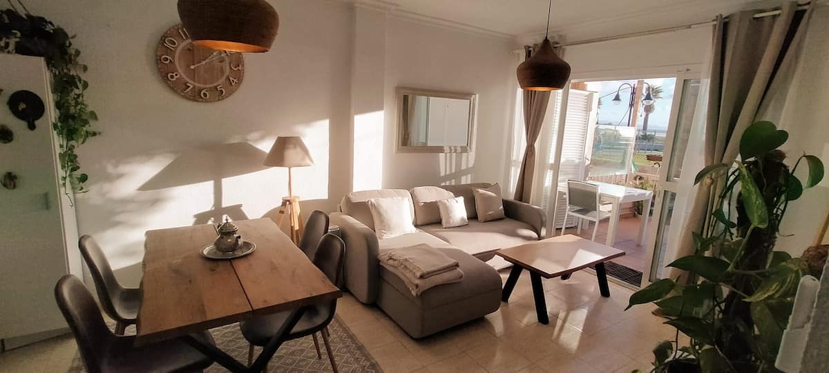 Salón luminoso con sofá y decoración mediterránea en Casa Tarifa