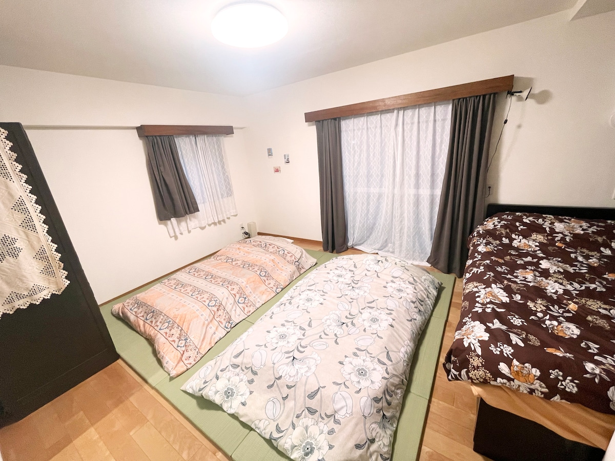 榻榻米垫上有2张日式床垫，旁边有1张双人床。