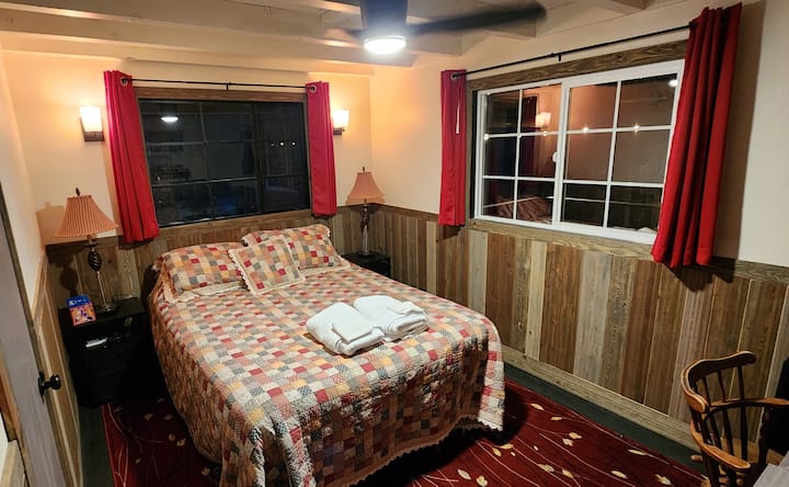 Chumba cha kulala cha ofisi kilicho na kitanda aina ya queen, dawati na kabati la nguo