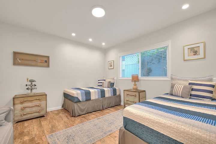 Detská spálňa s pobrežnou tematikou (na prízemí) s 2 samostatnými posteľami.  Farebná paleta je inšpirovaná pobrežnými prvkami s jemnou modrou, piesočnatou béžovou a bielou farbou pripomínajúcou more a pláž.