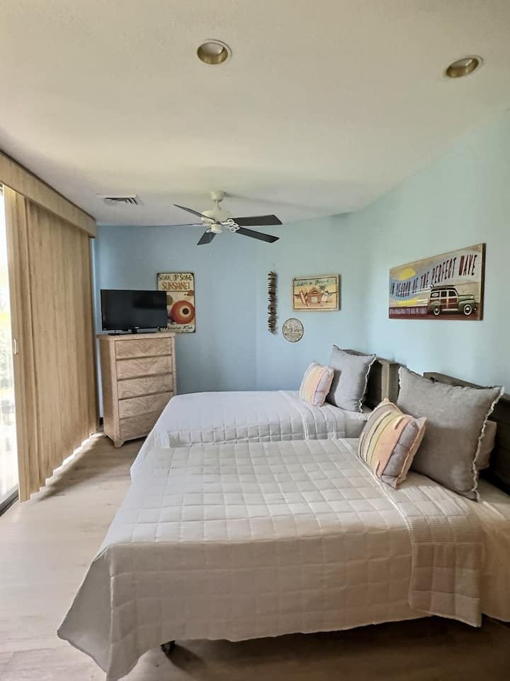 两张单人床、一台电视和一扇滑动玻璃门，自然采光充足。