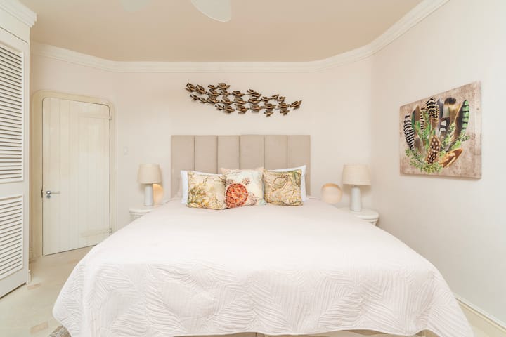Slaapkamer 5 met eigen badkamer, kingsize bed, uitzicht op de golfbaan en airconditioning.