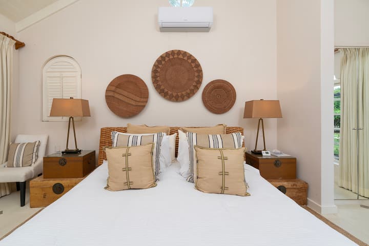 Met natuurlijke tinten en accenten, slaapkamer 1 van het huisje heeft een UK kingsize bed, een eigen doucheruimte en uitzicht op de tuin.