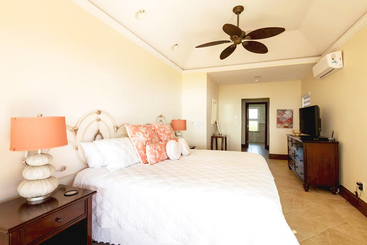 Arriba, el tercer dormitorio está completo con una cama tamaño king, baño y una terraza compartida con vistas al mar.