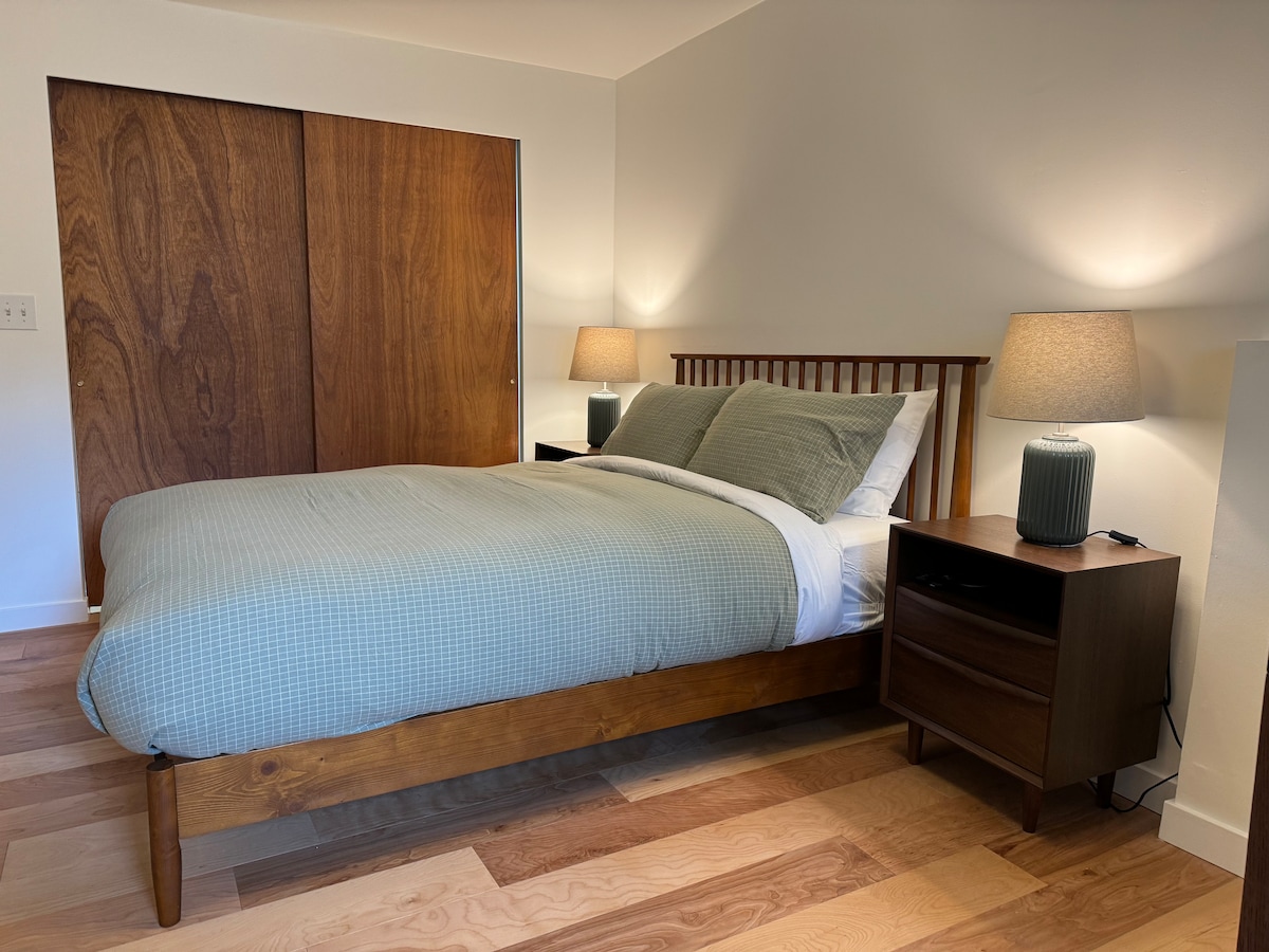 Táto spálňa v suteréne je trochu oddelená od prenájmu domu bez izieb nad ním, čo z neho robí pokojnejší priestor na spanie a prácu. Matrac Queen je zbrusu nový matrac Nektar. Spálňa má vyššie stropy približne 2,5 metra.