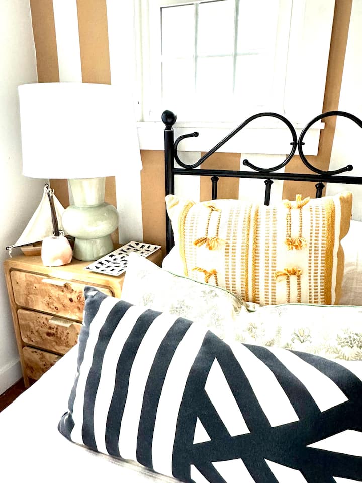 Two twin beds with matching burl wood side tables.  A wall mounted TV and a big closet for luggage. 