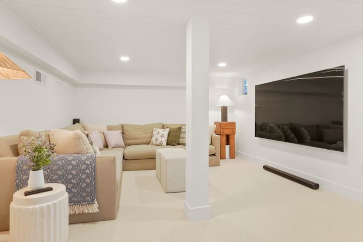Cozy basement media room with 86” TV and Sonos surround sound—perfect for movie nights and relaxing after a day out.