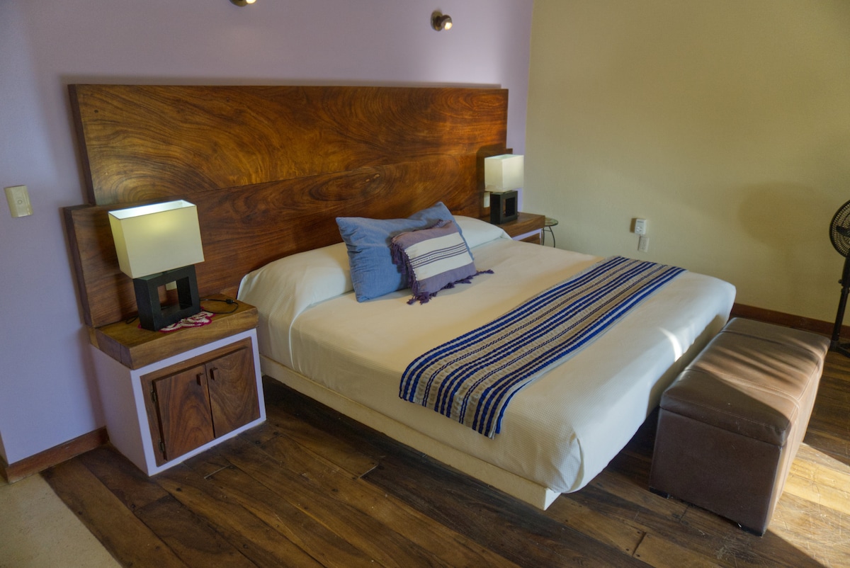 A beautiful and comfortable king-size bed where you can relax and enjoy the air conditioning after a day at the beach. 
