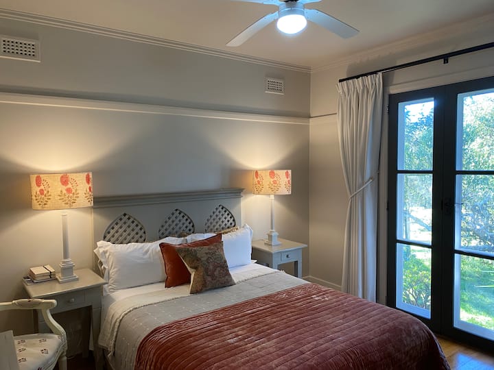 Habitación con cama tamaño queen, TV de alta definición, ventilador de techo, calefactor y asientos ocasionales.