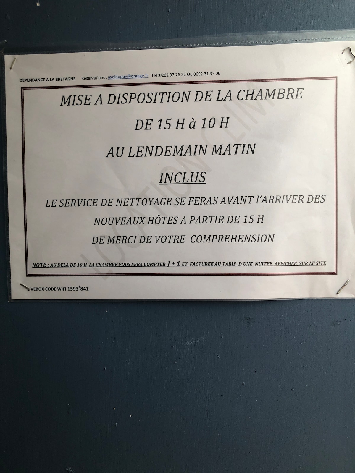 A notice is displayed on a wall, conveying information about room availability from 3 PM to 10 AM the following morning. The notice includes guidelines regarding cleaning services before new guests' arrival. The notice is clear and easy to read, positioned prominently.