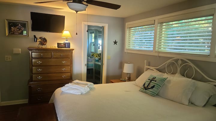 חדר שינה מרווח 'High Tide' עם מיטת קינג סייז, טלוויזיה וחדר רחצה צמוד