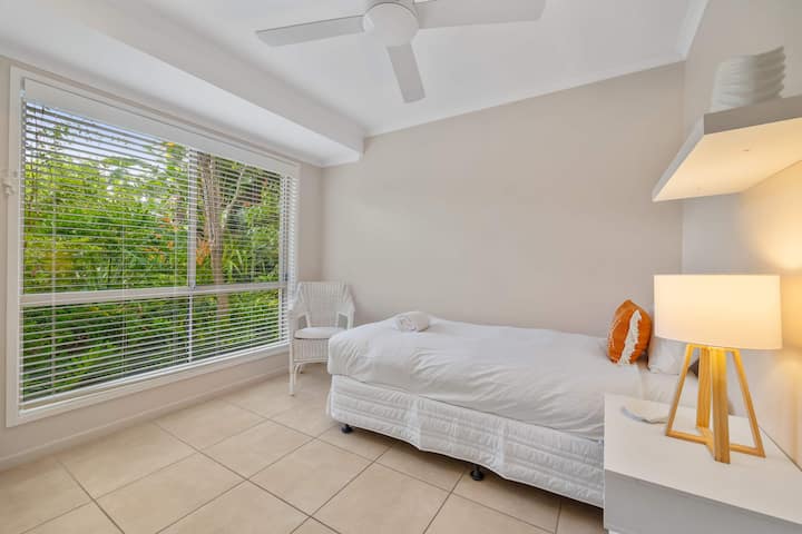 The third bedroom is set with a single bed and ceiling fan.