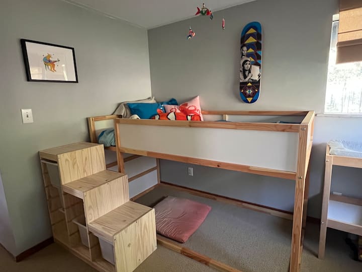 Chumba cha kulala cha mtoto kilicho na meza ya kubadilisha na midoli.