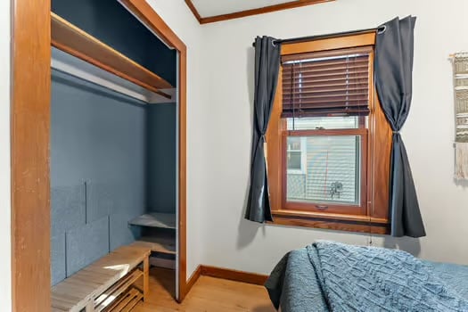 Slaapkamer één aan de voorkant van het huis, jaloezieën en verduisterende gordijnen. Bevat een queensize bed en kast voor opslag.