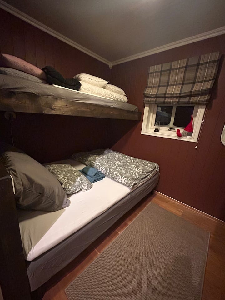 ห้องนอนสีแดง - ที่นอน 3 หลังเตียง 140 ซม. และเตียงสองชั้นบน 80 ซม. ห้องพักมีพื้นที่ทำงานพร้อมหน้าจอ