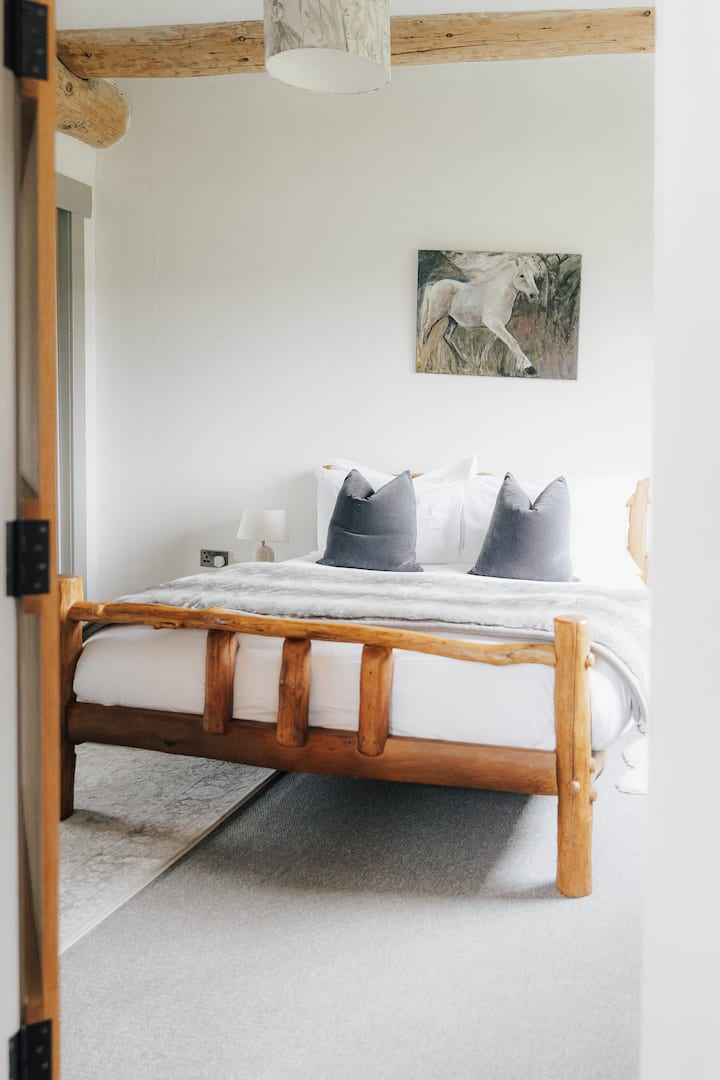 The spacious double bedroom on the ground floor has a beautiful view to the woods and the sunrise in the East. Shower room and toilet next door. 
.