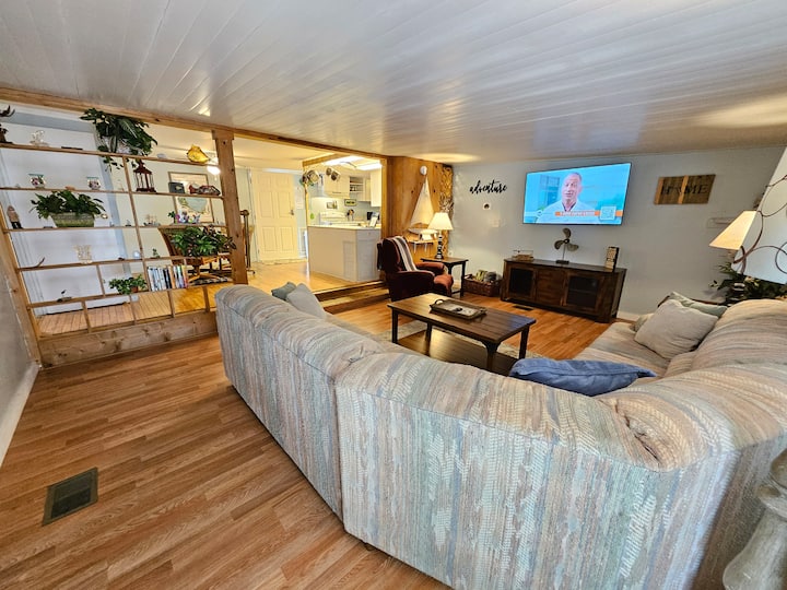 Sebule kubwa yenye televisheni janja ya inchi 65, sofa ya sehemu na kitanda cha malkia na kiti cha kuegemea. Pumzika na ufurahie!