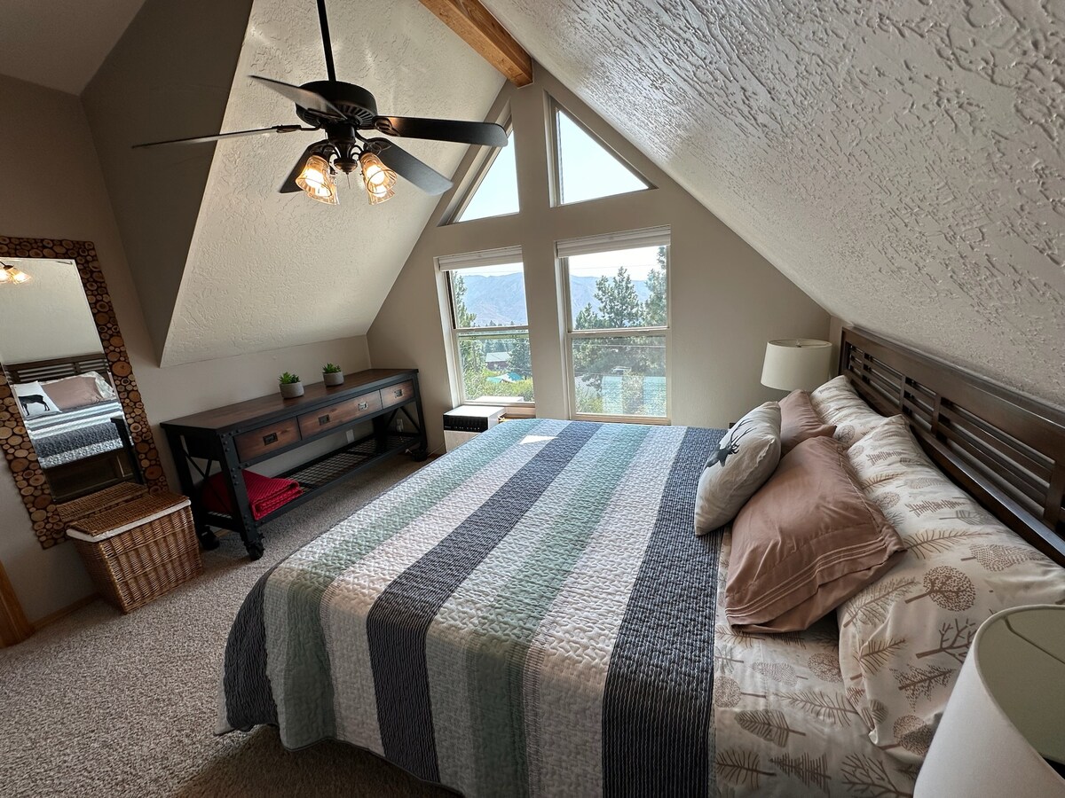The primary bedroom features a California king bed, walk-in closet, bedside tables with power/charging access for devices, a TV with Roku, and phenomenal views. Situated on the second floor, this bedroom/bathroom offer additional privacy.