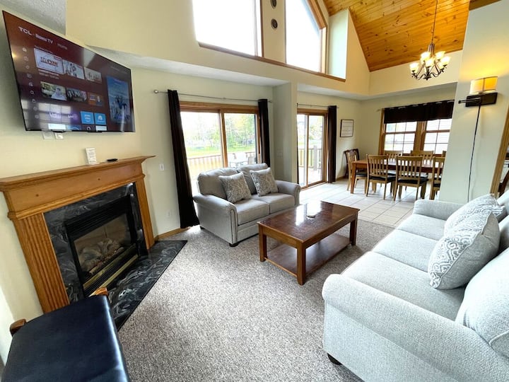 Sala de estar con asientos acogedores, sofá cama tamaño queen, TV y chimenea