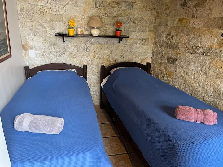 3号卧室设有两张单人床、冷气、风扇和有线电视。