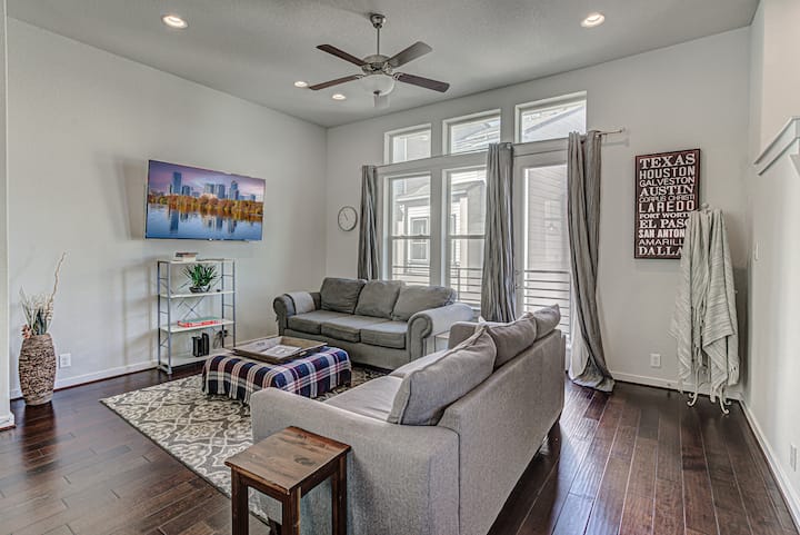 Moderná, otvorená obývacia izba s dvoma rozkladacími pohovkami Queen, inteligentnou televíziou a oknami od podlahy až po strop - ideálne na relaxáciu, streamovanie alebo spanie ďalších hostí v pohodlí v blízkosti The Pearl & Riverwalk.