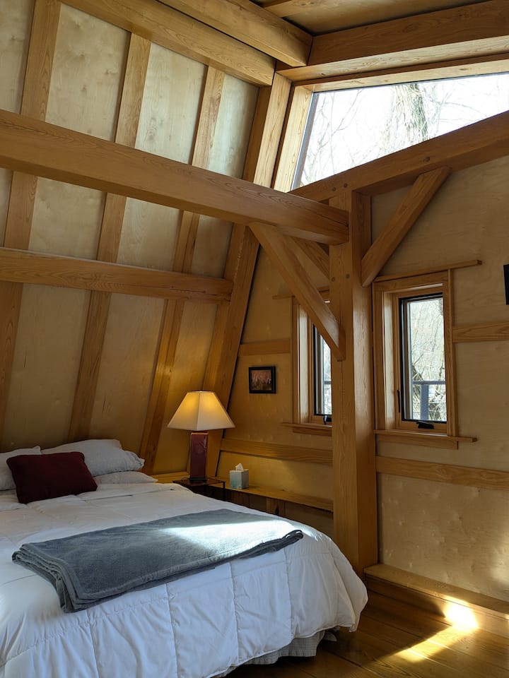 Upper bedroom with en-suite bathroom, vaulted ceilings, and access to upper deck