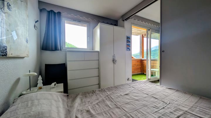 Uzavretá izba so 160 x 200 cm posteľou a komodou na odkladanie.