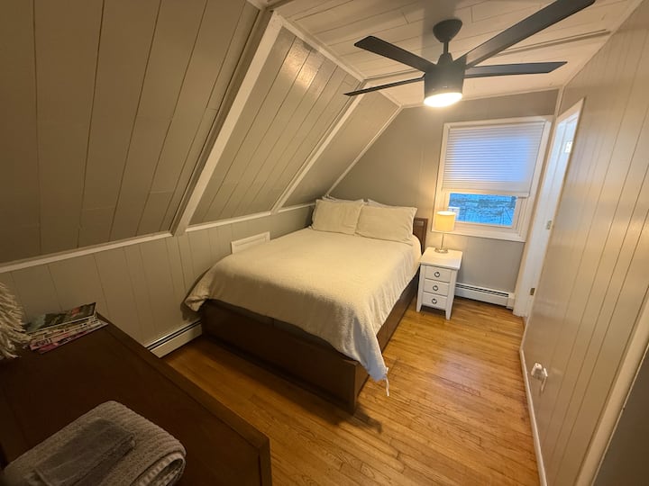 Second floor bedroom with attached bathroom, well appointed with a queen bed.
