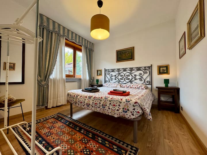 Svijetla i dobro održavana dvokrevetna soba s krevetom od kovanog željeza i pogledom na zelenilo. Klasičan namještaj, parket i elegantne zavjese za opuštajući odmor u srcu Bardonecchie.