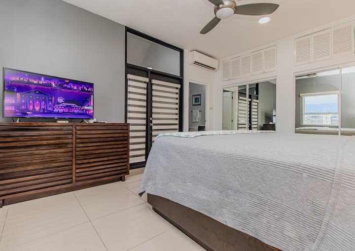 ห้องนอนเพนท์เฮาส์กว้างขวางมีเตียงคิงไซส์ทีวี 4K อัจฉริยะเคเบิลทีวีเตารีดโต๊ะรีดผ้าชั้นวางของพร้อมชั้นวางรองเท้าไม้แขวนเสื้อเครื่องปรับอากาศและห้องน้ำในตัว