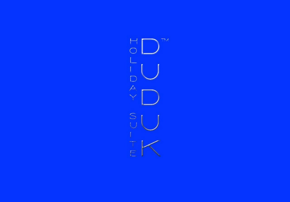 A bold blue background prominently displays the logo for DUDUK Holiday Suite, featuring the words 'DUDUK' and 'Holiday Suite' in a modern, stylized font that reflects a contemporary aesthetic.