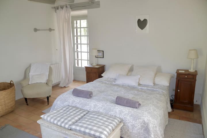 เตียงคิงไซส์ในห้องนอนใหญ่พร้อมผ้าปูที่นอนที่มีเส้นด้ายหนาแน่น