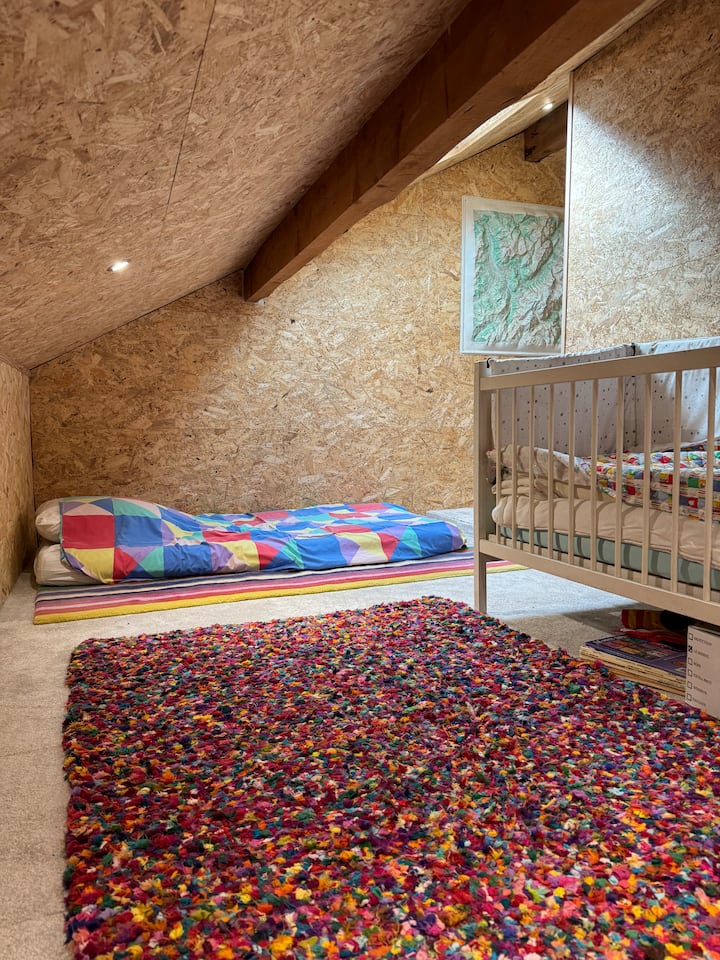 Habitación abuhardillada para dormir adicional con colchón en el suelo y cuna . Se puede añadir un segundo colchón en el suelo . Cerca de baño y aseo 