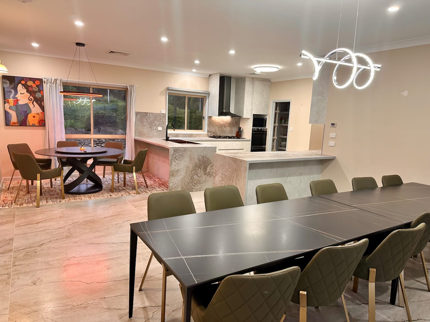 Long dining table and round dining table beside the open-plan kitchen