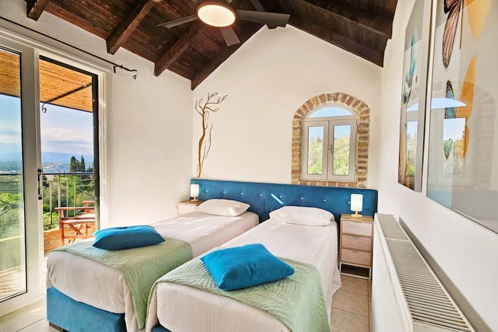Flexible top-floor bedroom in the Main Villa with twin beds convertible into a king-size bed and a private balcony with views