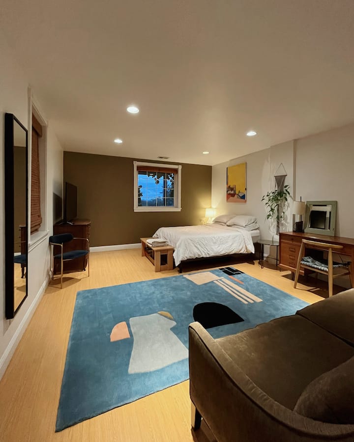 Спалня на по - ниско ниво. Двойно легло, бюро и диван, голям телевизор