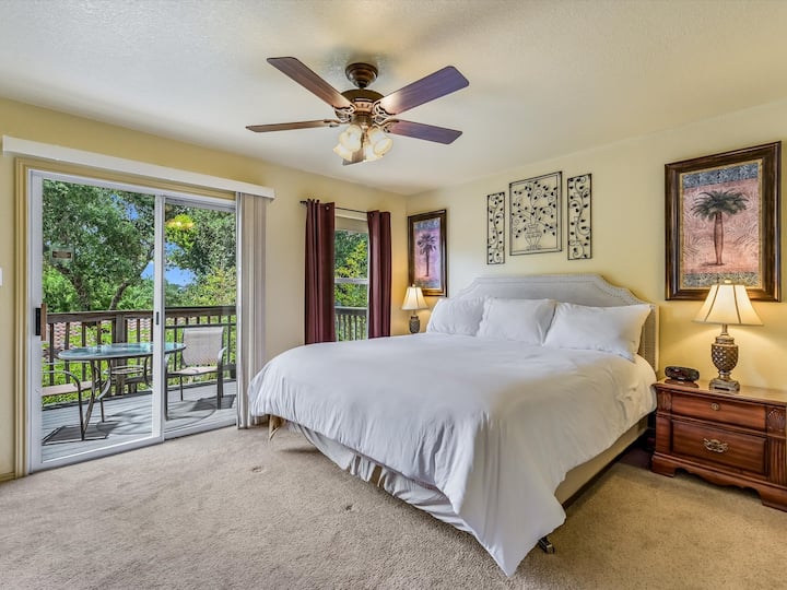 Garden House Upstairs King Red Bedroom with flat screen tv, walk in closet, balcony, power/usb on both sides of the bed, and an ensuite bathroom (note bedspread may be in a different color)