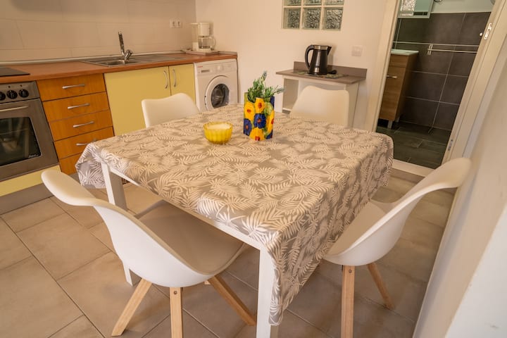 Cocina-comedor con lavadora, horno y mesa: práctica y luminosa.