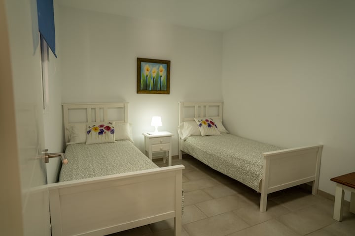 Dormitorio 2 con dos camas individuales y mesilla: ideal para amigos o niños.