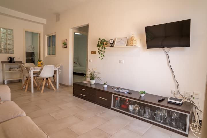 Salón con Smart TV, sofá y comedor al fondo: ambiente abierto ideal para la vida diaria.