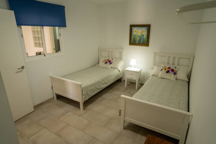 Dormitorio 2 con dos camas individuales y ventana: luminoso y bien equipado.