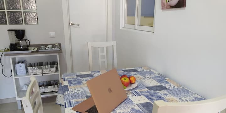 Comedor con mesa y sillas junto a la ventana: rincón luminoso para comer o teletrabajar.