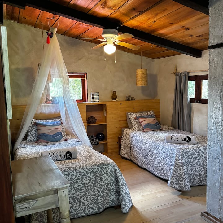 这间客房配备两张单人床、半个卫生间、小露台和书桌。 