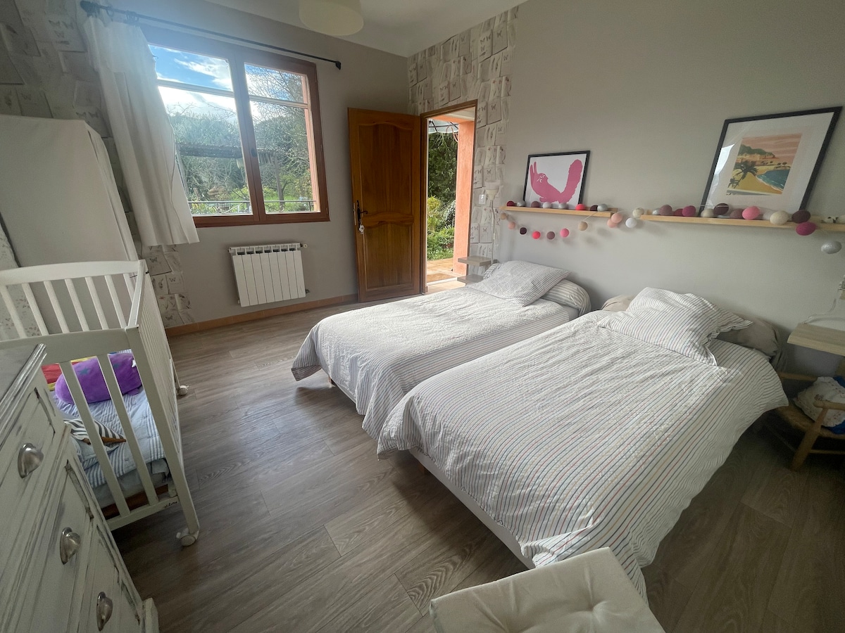 Slaapkamer met 2 één persoons bedden en wiegje