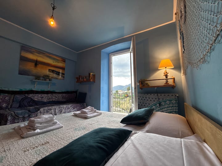 Bedroom. While lying comfortably on the bed, you can see the sea, hear its sound, and see all that panoramic landscape, because the bed is right next to the balcony. Fall asleep to the sound of the waves. It's a unique experience.