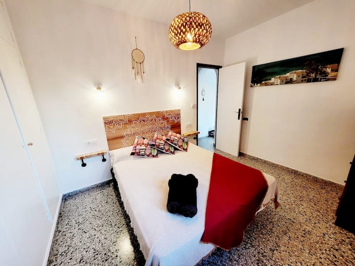 غرفة نوم 1 مع جدار من خزائن الملابس المجهزة وإطلالة على الحديقة الأمامية لشجرة النخيل