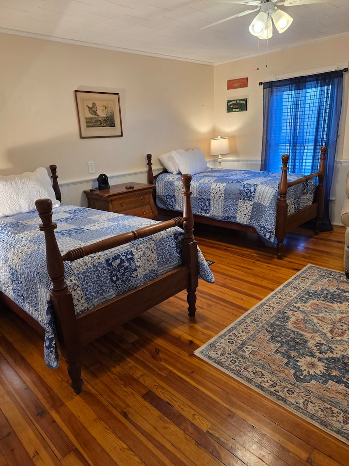 This is the Twin Room. It has a ceiling fan, 2 twin beds, air conditioning, an electric fireplace, and a 50-inch Roku TV.